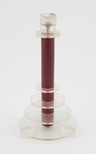 One of two maroon candlesticks with perspex rings and holder
