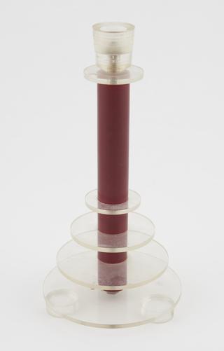 One of two maroon candlesticks with perspex rings and holder