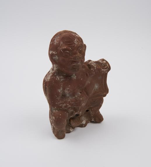 Hollow moulded terracotta figure of squatting man with