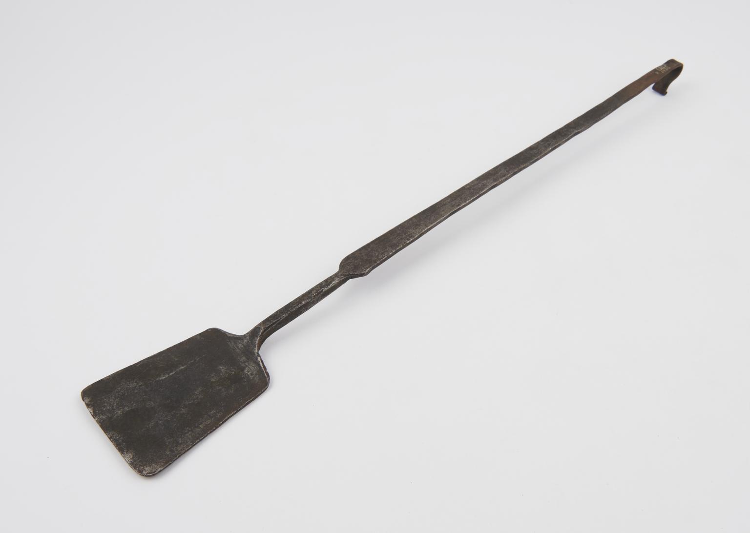 Iron instrument with flat shovel-like blade at one end and looped hook ...