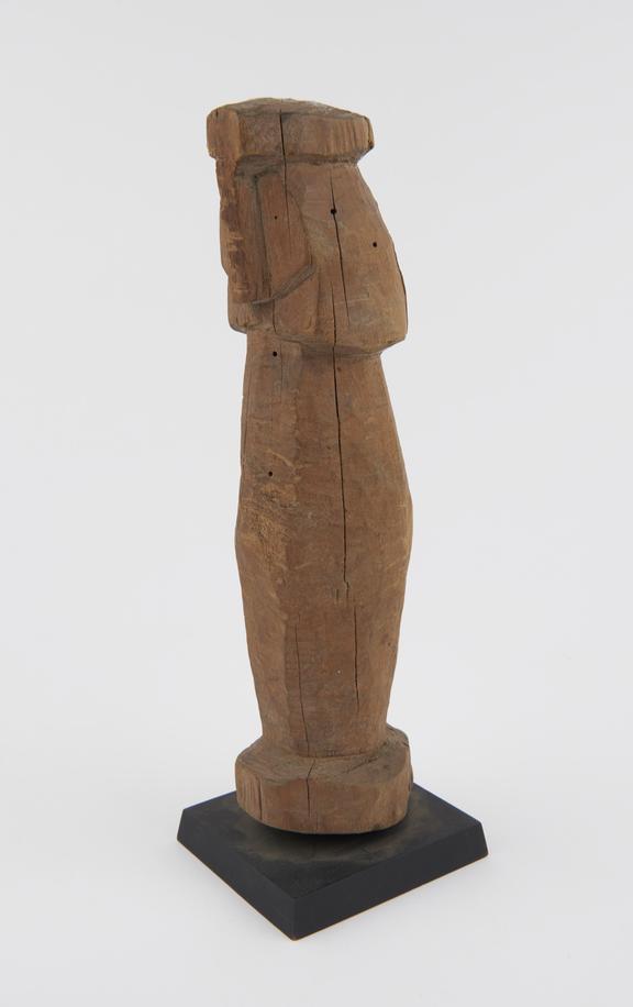 Roughly  carved wooden statue with an unfinished appearance