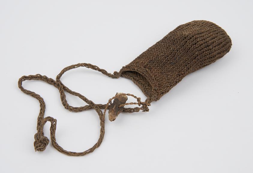 Knitted fibre bag, with loop, containing dried grass and wood