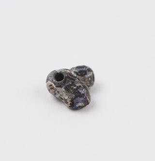 Small dark indescent glass bead moulded in form of male genitalia
