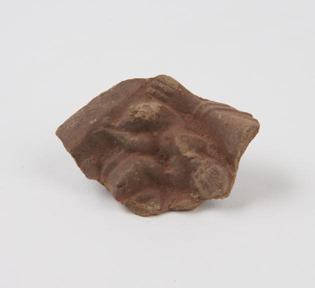 Fragment of enlarged earthenware pottery with moulded