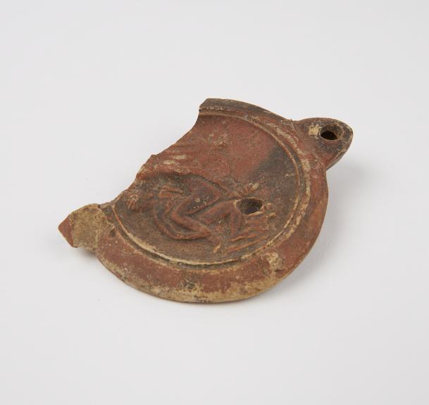 Broken terracotta lamp cover showing copulating couple, Roman