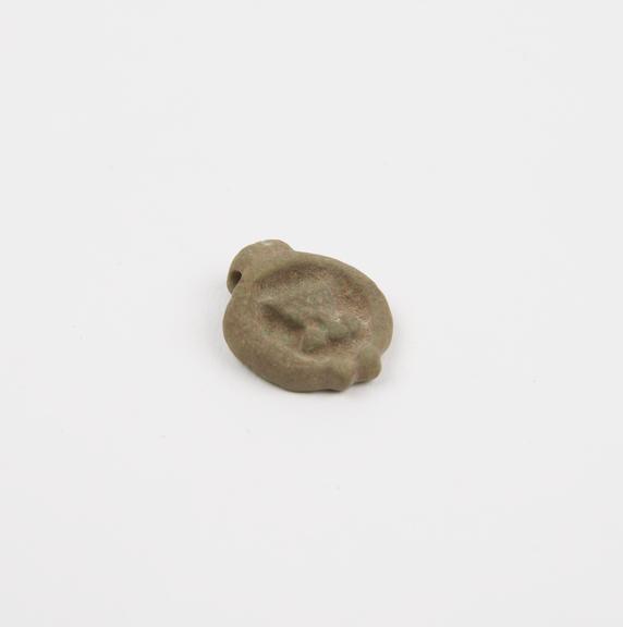 Oval green faience amulet, with male genitalia on front