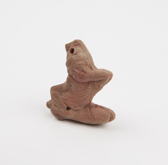 Amuletic terracotta pendant in form of figure astride enormous phallus (pendant; amulet; phallus)