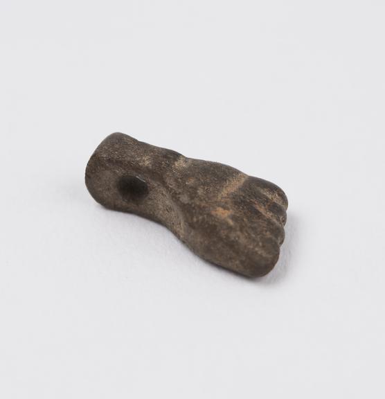 Small brown stone amuletic pendant in form of manofical hand