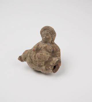 Small red stone bead carved in form of male genitalia