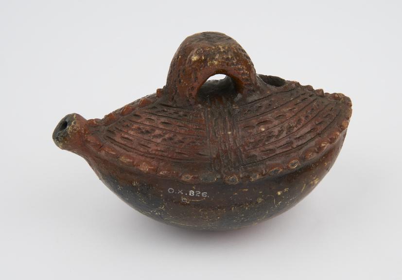 Earthenware vessel in the form of a boat with handle and spout