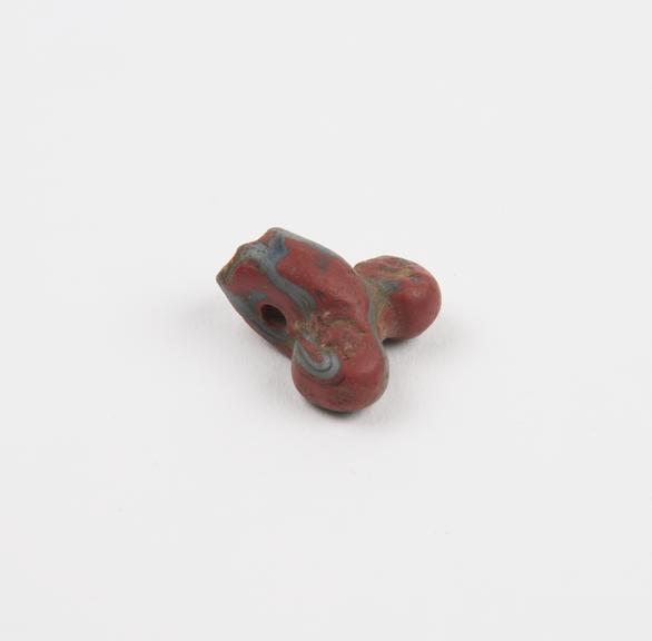 Amuletic pendant in form of male genitalia of moulded red glass