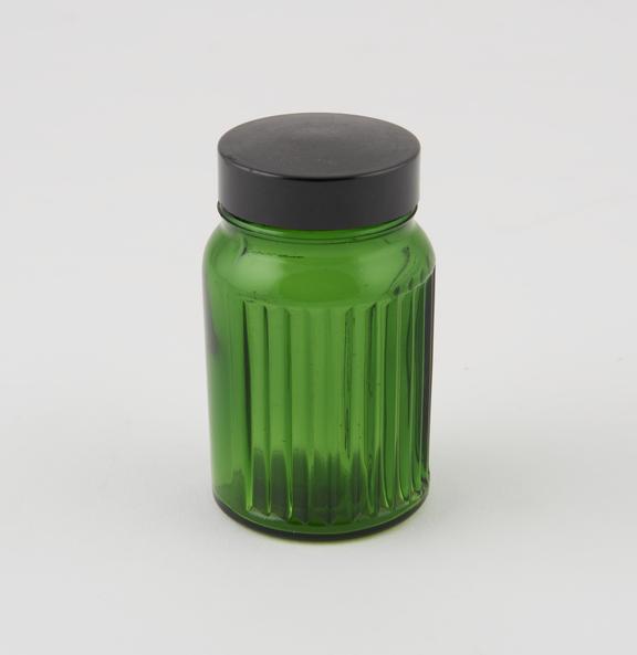 Small green glass jar with ribbed body, plastic screw top