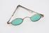 Silver 'eye-preserver' spectacles with small green oval lenses
