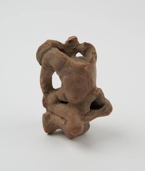 Hollow terracotta figure of a male sitting astride a large phallus (statue; phallus)