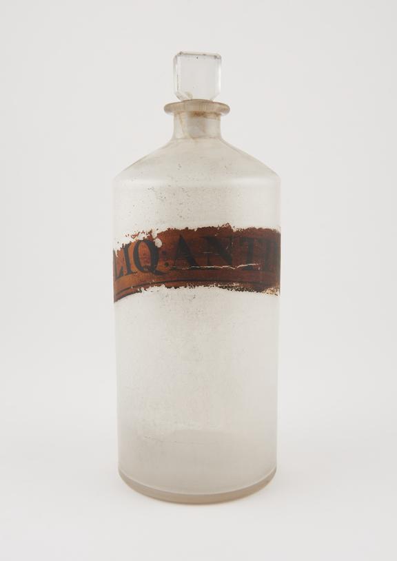 Bottle, clear glass, containing trace of white crystals