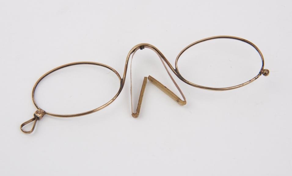 Gold rigid clip eyeglasses with oval lenses (lenses missing)