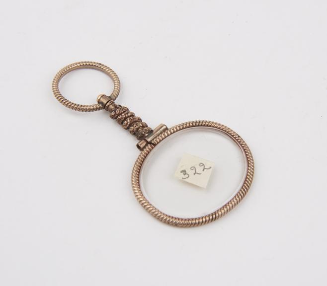 Single oval eyeglasses in knurled gold (?) frame with decorated