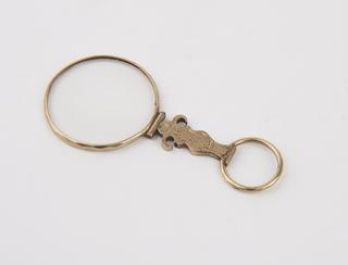 Single round eyeglass in decorated gold frame