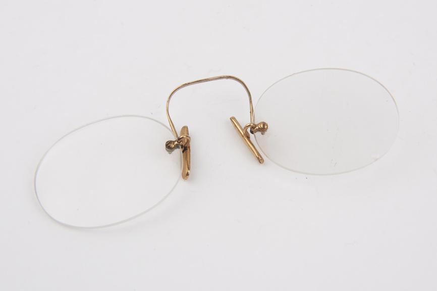 Gold rimless clip eyeglasses with oval lenses and cork plaquets