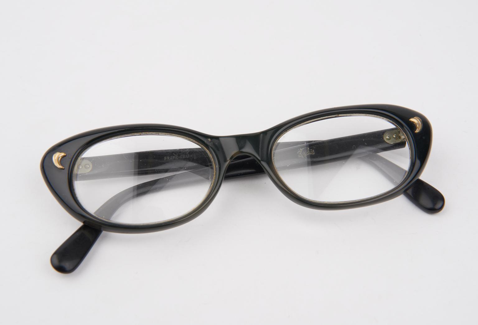 Black plastic frame spectacles, with brass 'leaf' decorations