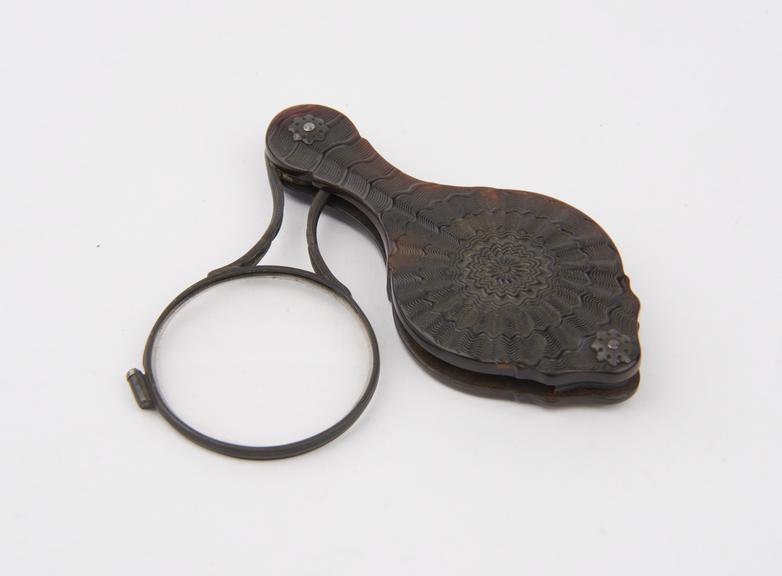 Metal-framed folding magnifying glass with ornamental