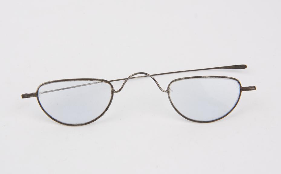 Pair of blue-tinted spectacles with one arm missing