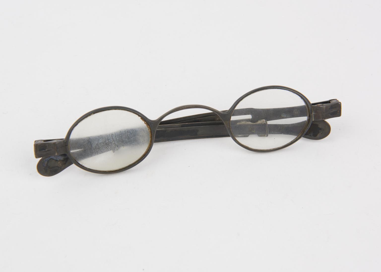 Silver framed spectacles with oval lenses and folding arms with slide ...