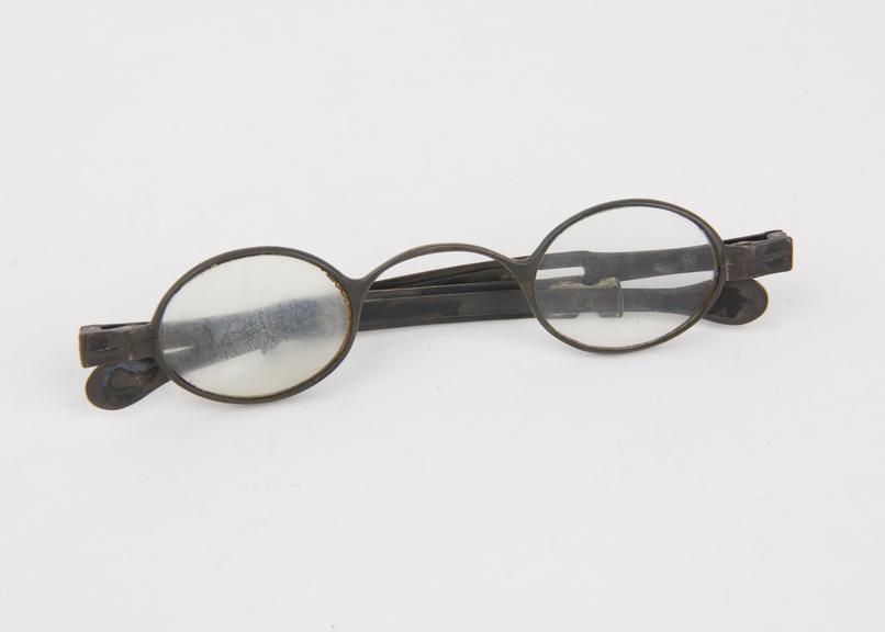 Silver framed spectacles with oval lenses and folding arms with