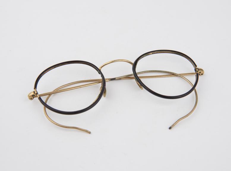 Pair of round rimmed spectacles with metal frames covered with