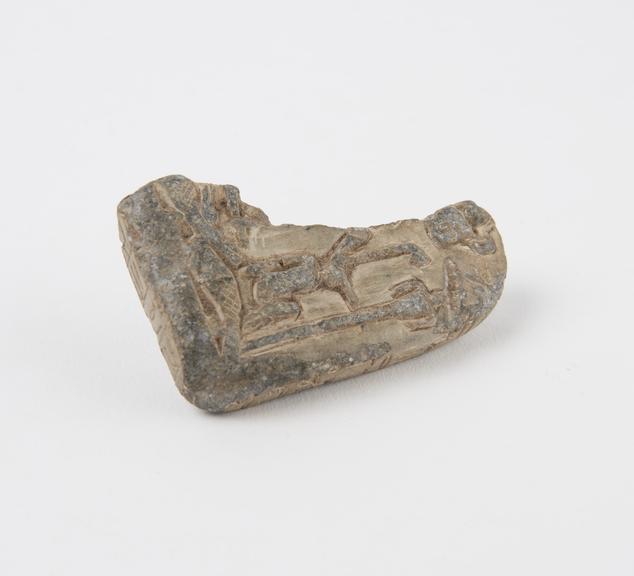 Fragment of soapstone tablet showing animal figure with