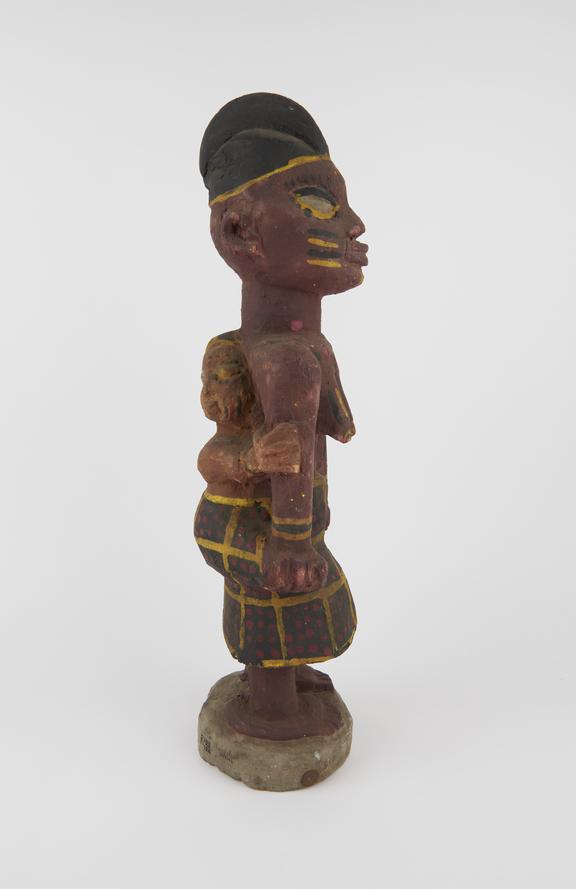 Carved wooden figure of female carrying child on back