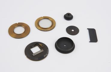 Six brass eyepiece components, plus a steel component, from Groth's universal apparatus