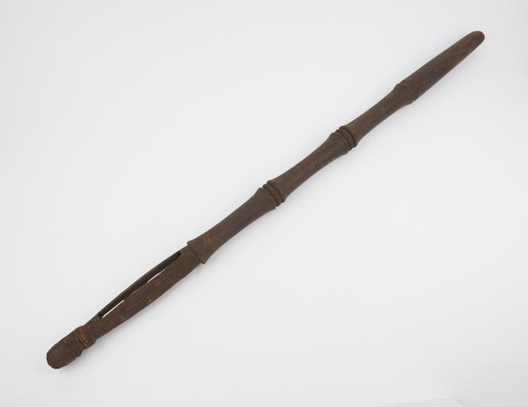 Carved wooden staff with rattle at top