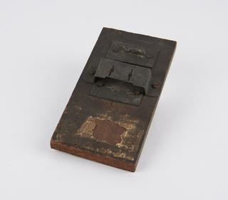 Slotted metal assembly on wooden base