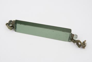 Green demonstration glass prism with cord attached to mounting lugs at eachend