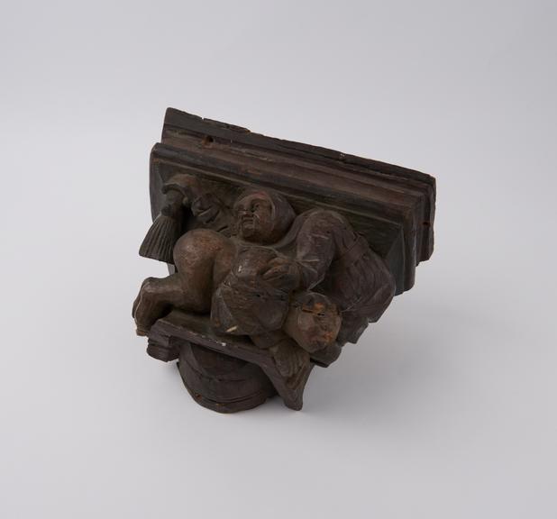 Carved wooden corbel with a scene of (?)sado-masochistic