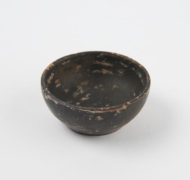 Minature black bowl, slightly concave sides, flat bottomed