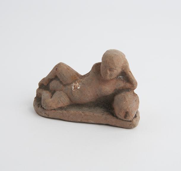 Solid terracotta figure of a phallic male, reclining