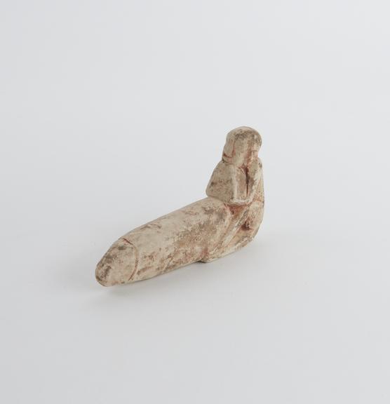 Small pottery figure of seated male leaning on priapus