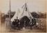 Men seated outside their team tent