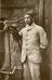 A photograph of a man posing with his bicycle