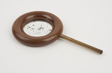 Concave mirror, in wooden ring on brass rod