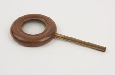 Concave lens, in wooden ring on brass rod