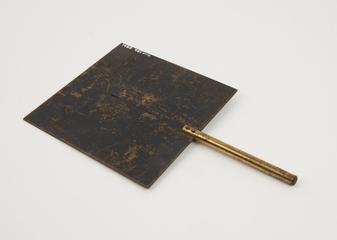 Square metal plate with vertical slit, on metal rod