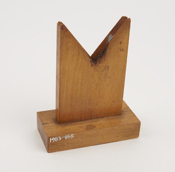 Lens holder consisting of a wooden upright with a v-shaped slot