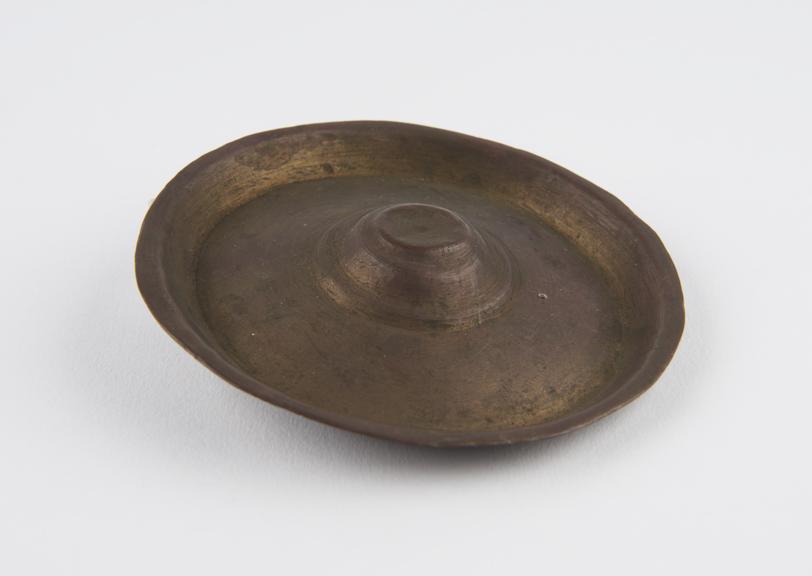 Circular brass vessel, conical in centre with very wide rim