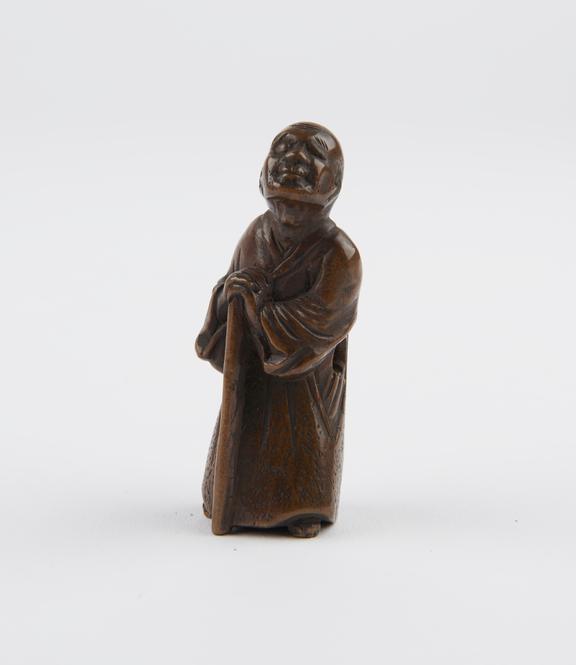 Wooden netsuke, in the form of a blind man leaning on a stick