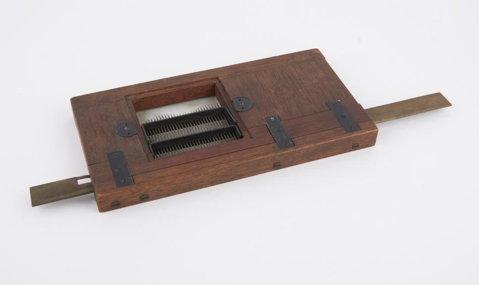 Mechanical lantern slide containing a row of needles arranged