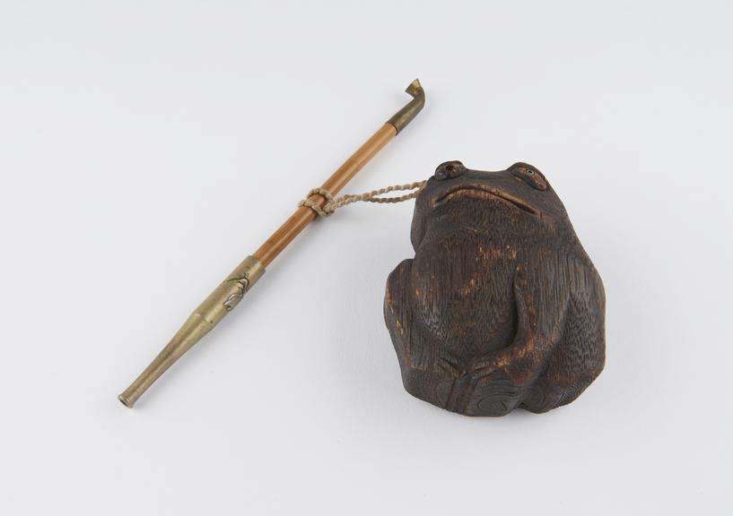 Tobacco pipe, attached by cord to wooden frog tonkatsu