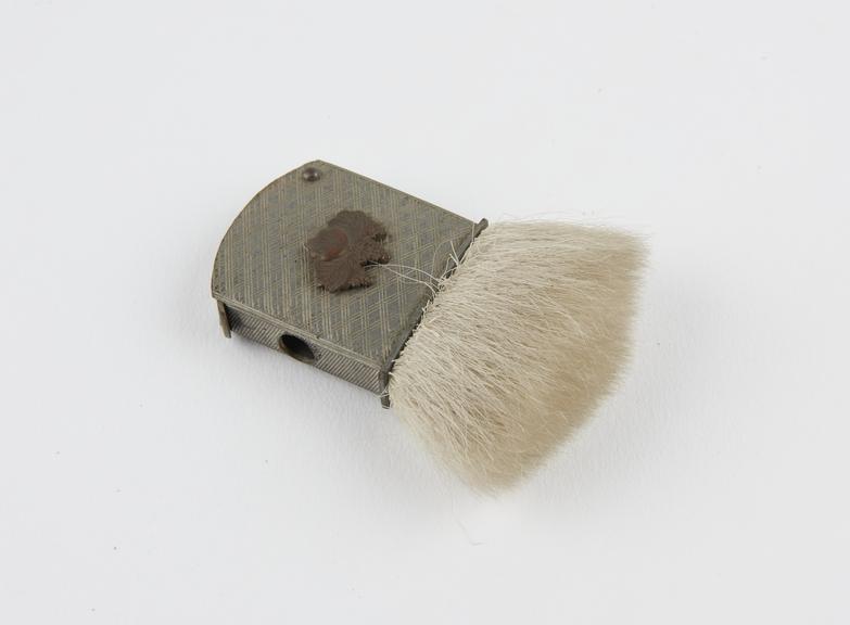 Hair brush set into metal holder